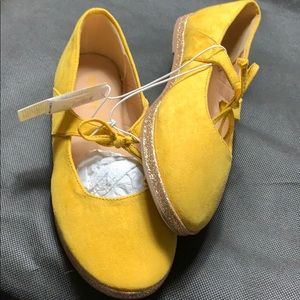 Flat slip on shoe with tie.